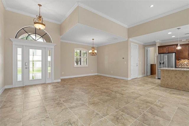 entrance foyer with light tile patterned floors, crown molding, and a chandelier