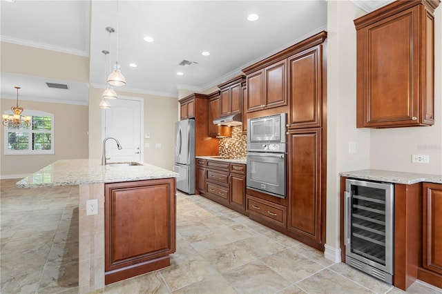 kitchen with stainless steel appliances, pendant lighting, wine cooler, an island with sink, and sink