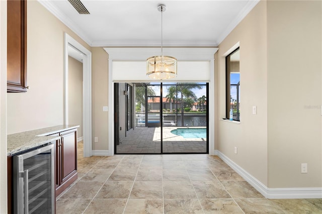 interior space with light tile patterned floors, wine cooler, and ornamental molding