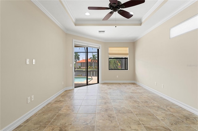 unfurnished room featuring ornamental molding, a tray ceiling, visible vents, and baseboards