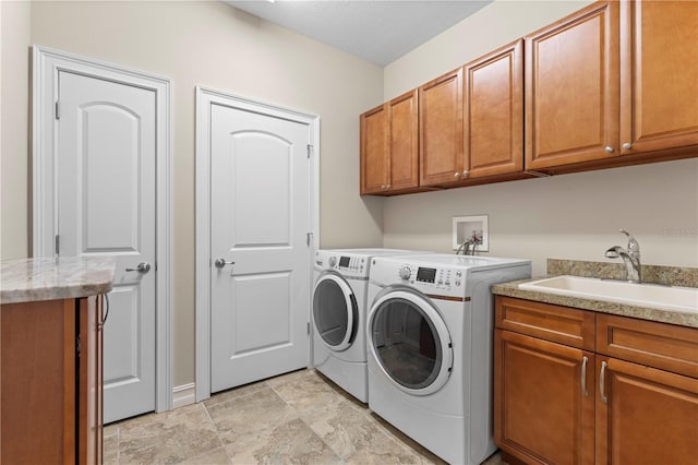 laundry room with light tile patterned flooring, washing machine and dryer, cabinets, and sink