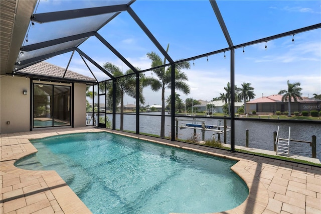 view of swimming pool with glass enclosure, a patio, and a water view