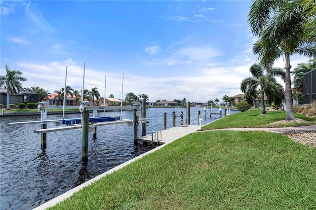 view of dock with a lawn and a water view