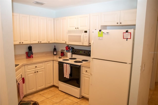 kitchen featuring light tile patterned floors, white appliances, and white cabinetry