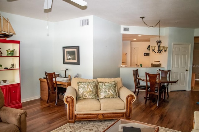 living room with ceiling fan with notable chandelier and hardwood / wood-style flooring