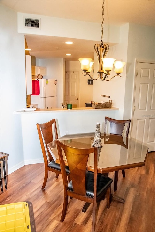 dining room with a notable chandelier and light hardwood / wood-style floors