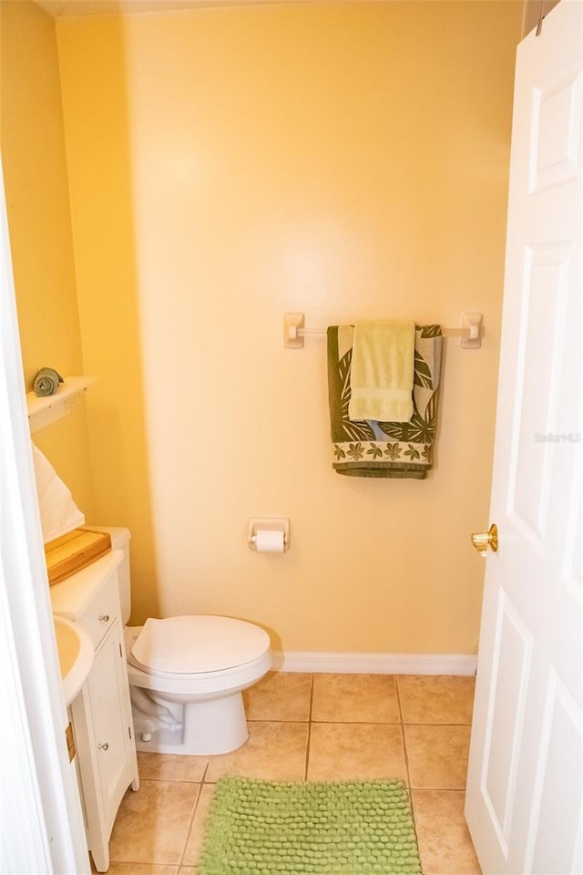 bathroom with toilet, vanity, and tile patterned flooring