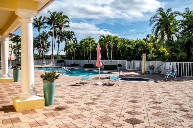 view of pool with a patio and a hot tub