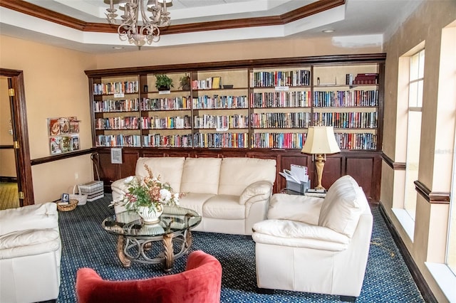 sitting room featuring a notable chandelier, ornamental molding, carpet floors, and a raised ceiling