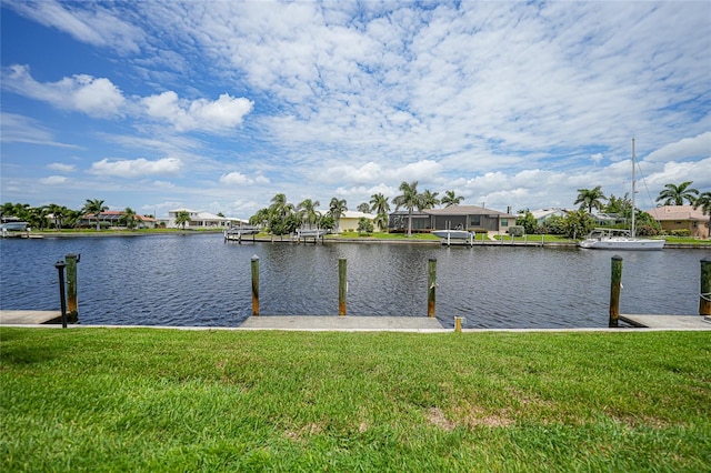 view of dock with a yard and a water view