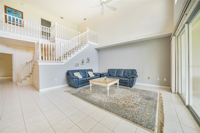 tiled living room featuring ceiling fan and a towering ceiling