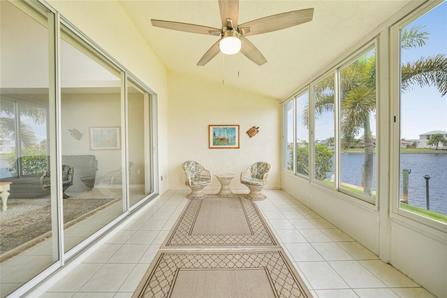 unfurnished sunroom with ceiling fan, vaulted ceiling, and a water view