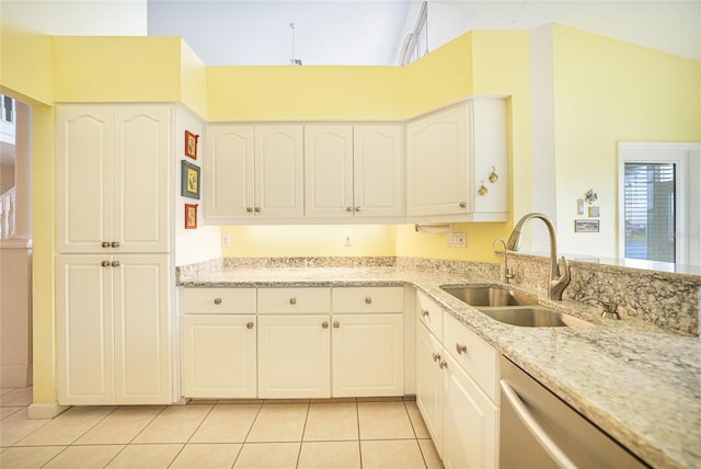 kitchen featuring sink, dishwasher, lofted ceiling, and light tile patterned floors