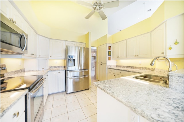 kitchen featuring light tile patterned flooring, sink, appliances with stainless steel finishes, ceiling fan, and white cabinets