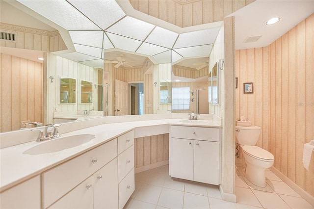 bathroom with wood walls, tile patterned floors, vanity, ceiling fan, and toilet