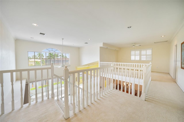 hallway with light colored carpet and ornamental molding