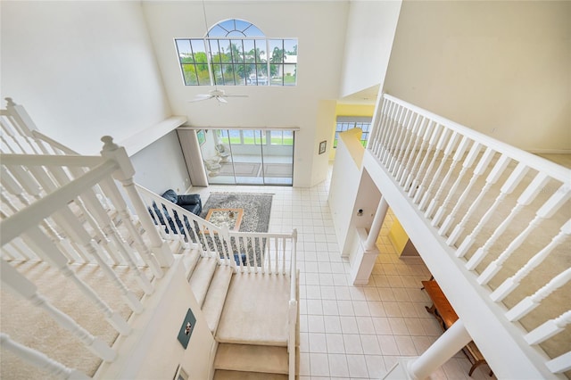 entryway featuring ceiling fan, a high ceiling, and tile patterned floors