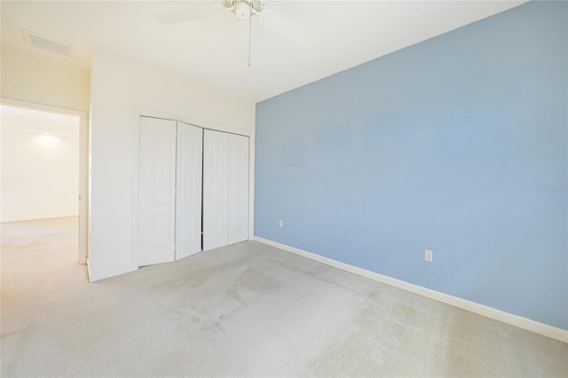 unfurnished bedroom featuring ceiling fan, light carpet, and a closet