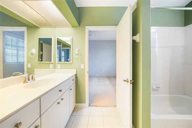 full bathroom with shower / bath combination, tile patterned flooring, baseboards, and vanity