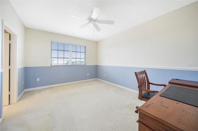 office space featuring light carpet, a ceiling fan, and baseboards