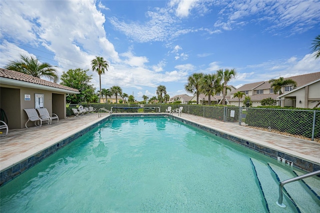 pool featuring a residential view, fence, and a patio