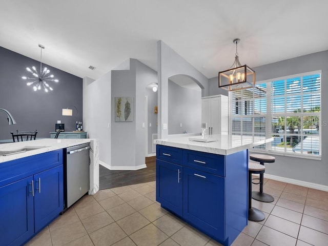 kitchen featuring stainless steel dishwasher, a kitchen island, light tile patterned floors, sink, and lofted ceiling