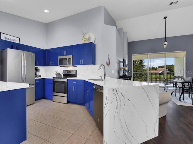 kitchen featuring stainless steel appliances, light hardwood / wood-style floors, tasteful backsplash, sink, and light stone counters