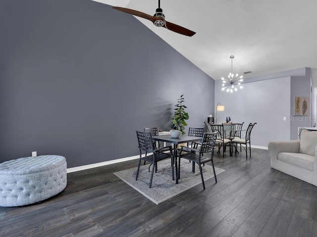 dining area with vaulted ceiling, ceiling fan with notable chandelier, and dark wood-type flooring