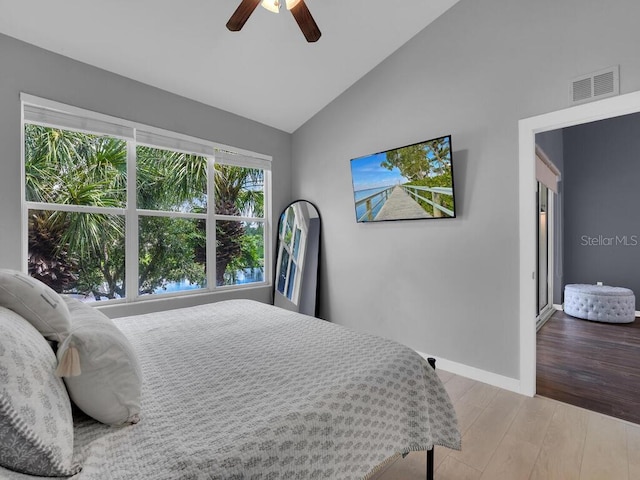 bedroom with ceiling fan, high vaulted ceiling, and light hardwood / wood-style flooring