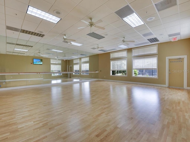 workout room featuring ceiling fan, a drop ceiling, and light hardwood / wood-style flooring