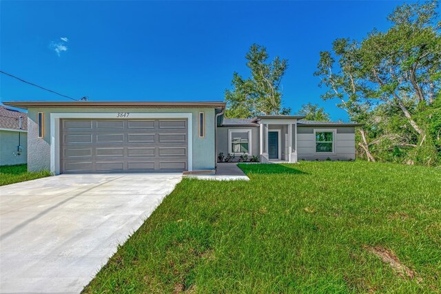 4582 Enid Ln, North Port, FL 34288 - ranch-style home with a garage, a front lawn, driveway, and stucco siding