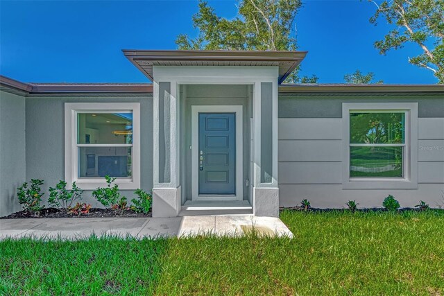 4582 Enid Ln, North Port, FL 34288 - property entrance with a yard and stucco siding