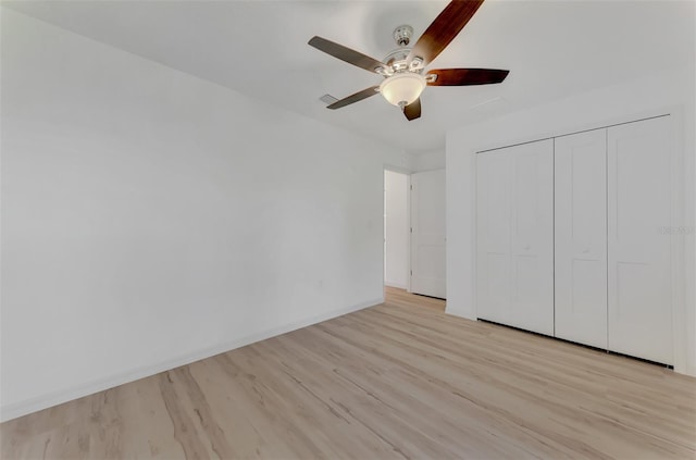 unfurnished bedroom featuring ceiling fan, a closet, and light hardwood / wood-style floors