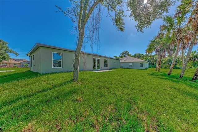 4582 Enid Ln, North Port, FL 34288 - back of house with stucco siding and a yard
