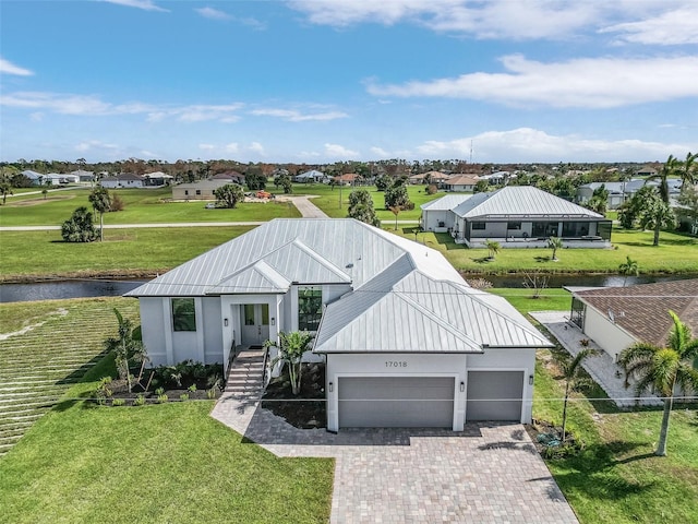 view of front of home with a front lawn and a water view