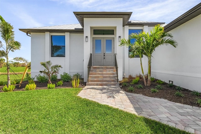 view of exterior entry featuring a yard