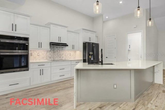 kitchen with white cabinets, a center island with sink, tasteful backsplash, light hardwood / wood-style floors, and black appliances