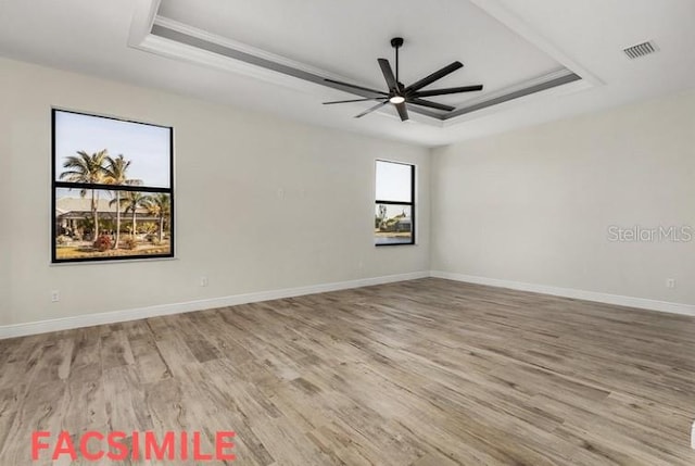 unfurnished room with a tray ceiling, ceiling fan, and light hardwood / wood-style floors