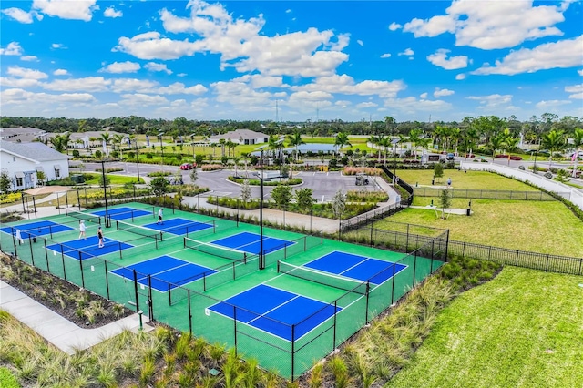 view of sport court featuring a yard, fence, and a residential view