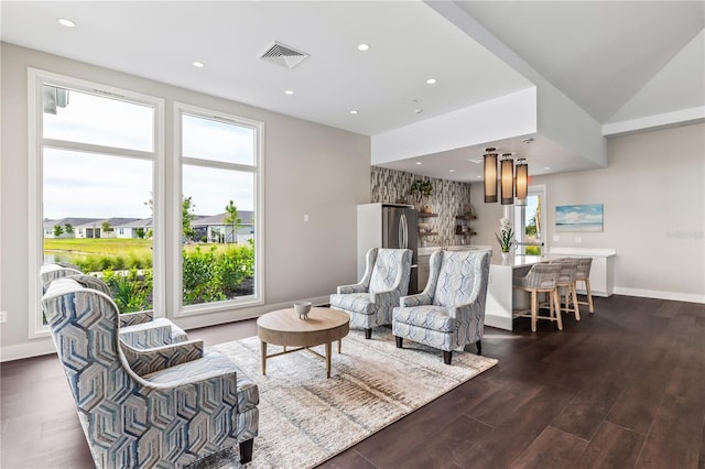 living room featuring dark wood-style floors, recessed lighting, a healthy amount of sunlight, and visible vents