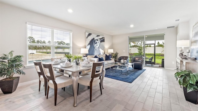 dining space with light wood finished floors, recessed lighting, visible vents, and a healthy amount of sunlight