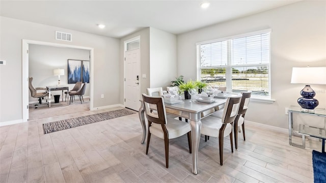 dining space featuring light wood finished floors, baseboards, visible vents, and recessed lighting