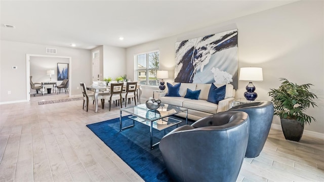 living area featuring recessed lighting, light wood-type flooring, visible vents, and baseboards