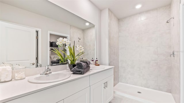 full bath with double vanity, a stall shower, a sink, and recessed lighting