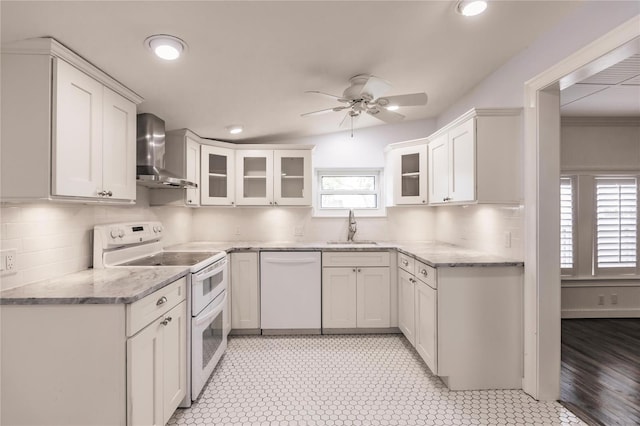 kitchen featuring a wealth of natural light, white appliances, wall chimney range hood, and light tile patterned floors