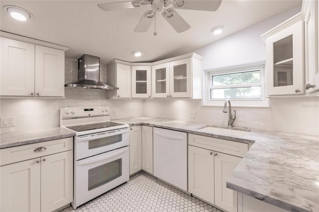 kitchen featuring wall chimney exhaust hood, decorative backsplash, sink, and white appliances