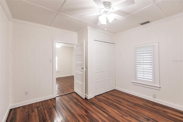 unfurnished bedroom featuring a closet, ceiling fan, dark hardwood / wood-style flooring, and crown molding