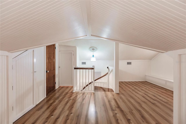 additional living space featuring lofted ceiling and hardwood / wood-style flooring