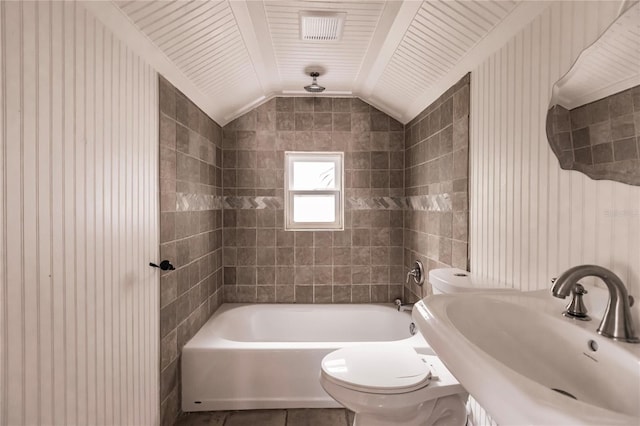 full bathroom featuring sink, lofted ceiling, toilet, wooden ceiling, and tiled shower / bath combo