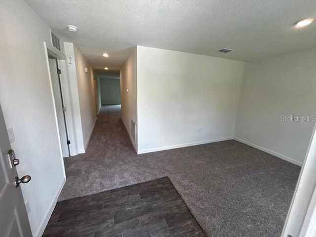 spare room with a textured ceiling and carpet floors